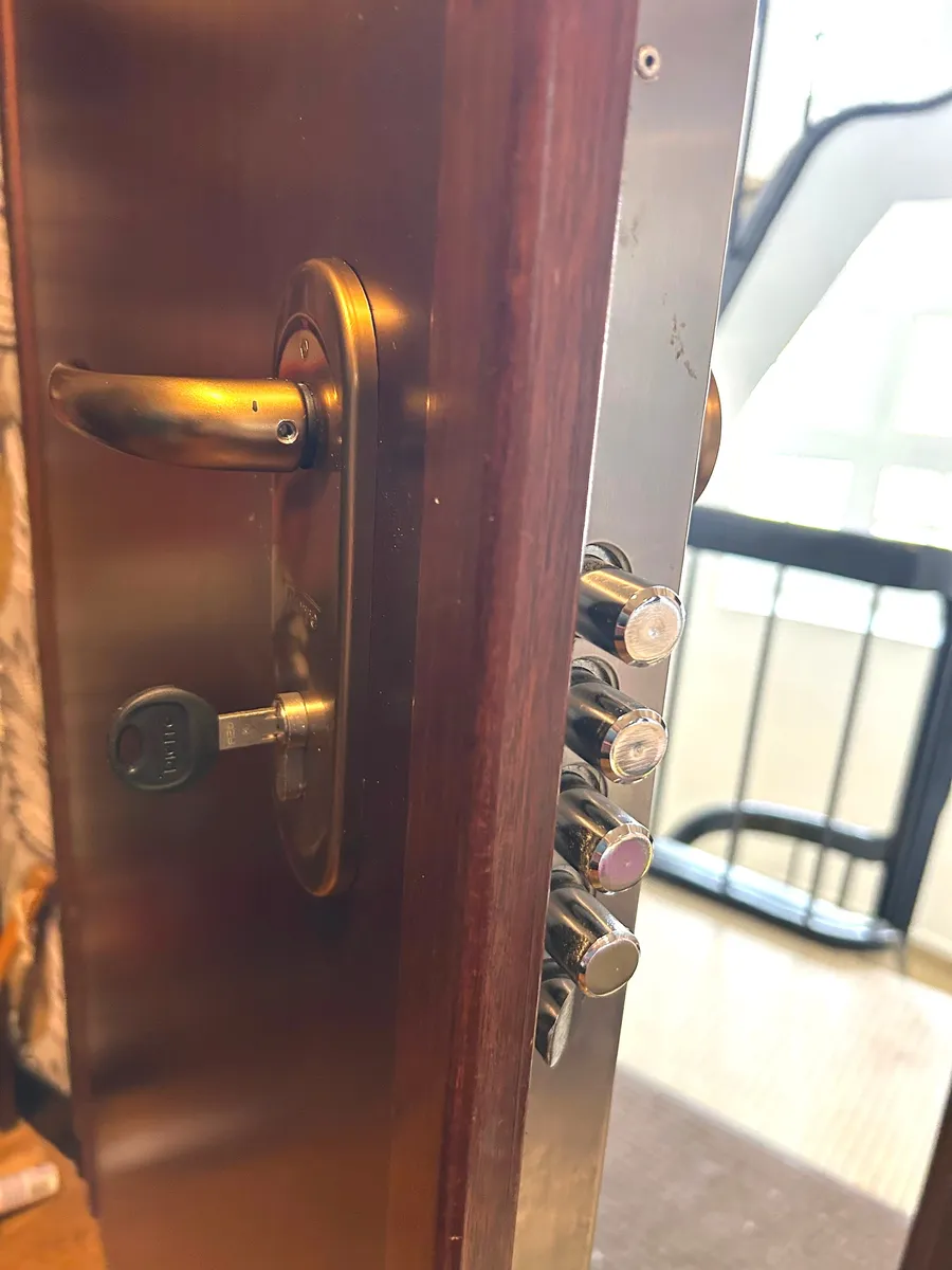 Poignée et serrure dorées sur une porte en bois foncé